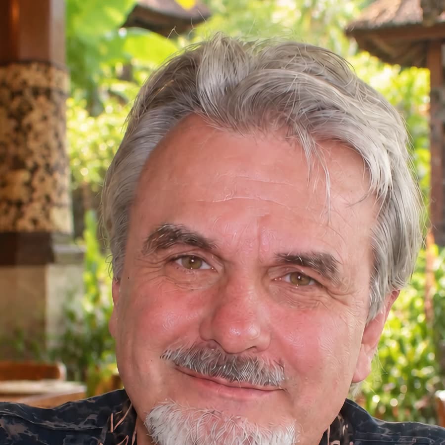 Kristopher Raphael smiling in a tropical temple garden
